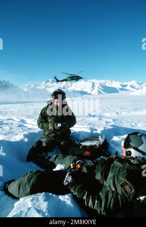 Coup de feu du sergent technique de la Force aérienne américaine Steve Lupenski, un parasecouriste au sein de l'escadron de sauvetage 210th de la Garde nationale aérienne de l'Alaska, alors qu'il se déroule pour atter la jambe du sergent technique de la Force aérienne américaine Brent Widenhouse en tant qu'hélicoptère Pavehawk de l'escadron de sauvetage 210th HH-60L qui se déplace à proximité. Cette image a été utilisée dans le numéro d'avril 1996 d'AIRMAN Magazine. Pays: Etats-Unis d'Amérique (USA) Banque D'Images