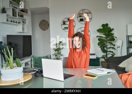 Jeune excitée heureuse femme étudiante gagnant succès en utilisant l'ordinateur. Banque D'Images