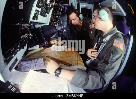 Navigateurs, 2nd Lieutenant Mathew C. Brennan (à droite, ville natale : Baltimore, Maryland) et Capitaine Rod F. Cosgrove (à gauche, ville natale : Colorado Springs, Colorado) de l'escadron de ravitaillement en vol 96th, base aérienne de Fairchild, Washington, vérifiez les cartes de navigation lors d'une mission dans un avion KC-135 au-dessus de la Jordanie à l'appui de la Force expéditionnaire de la Force aérienne. Une mission auxiliaire de la Force est d'aider l'US Air Force et d'autres forces multinationales opérant en Arabie Saoudite et dans d'autres pays voisins à patrouiller la zone d'exclusion aérienne au-dessus du sud de l'Irak. Opération/série de sujets : FORCE EXPÉDITIONNAIRE DE PUISSANCE AÉRIENNE Banque D'Images