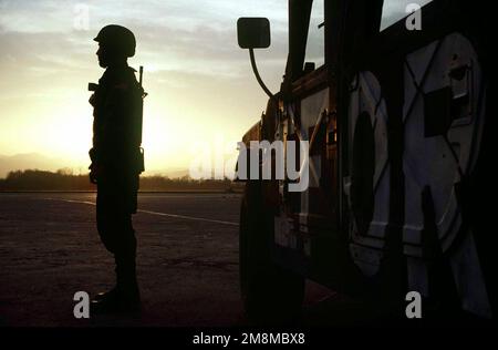L'AVIATEUR PRINCIPAL DE LA US Air Force Basso surplombe la ligne aérienne au crépuscule avant le changement de poste à la base aérienne de Tuzla, en Bosnie-Herzégovine. SRA Basso est UN SPÉCIALISTE de la police de sécurité de la Royal Air Force de 100th Mildenhall, en Angleterre, alors qu'il est temporairement affecté à la provisoire de groupe de 4100th à la base aérienne de Tuzla, en Bosnie-Herzégovine, à l'appui de l'opération JOINT ENDEAVOUR. Un chariot de forces d'implémentation se trouve sur le côté droit du tir. Objet opération/série: BASE CONJOINTE ENDEAVOUR: Tuzla Air base pays: Bosnie-Herzégovine (BIH) Banque D'Images