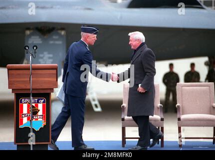 LE GÉN Richard E. Hawley, commandant du commandement du combat aérien, accueille le gouverneur de Caroline du Nord, Jim Hunt, sur la scène lors des cérémonies de dédicace du bombardier B-2, « Spirit of Kitty Hawk », stationné en arrière-plan. Date exacte prise de vue inconnue. Base: Seymour Johnson Air Force base État: Caroline du Nord (NC) pays: États-Unis d'Amérique (USA) Banque D'Images