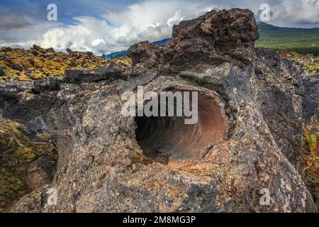 Un tube de houloche dans un bloc de lave solidifiée laissé après un tronc d'arbre a été couvert et brûlé par l'écoulement de lave Banque D'Images