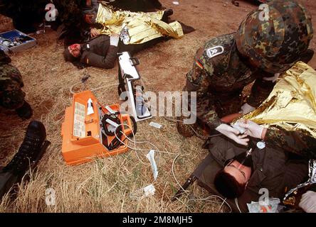 Des blessés simulés, suite à un accident de véhicule, sur une civière placée sur le sol, sont pris en charge par le personnel médical, du Centre de sauvetage de la Force aérienne allemande n° 1, au cours d'un exercice de victimes massives à Dona Ana Range, fort Bliss, Texas. Les soldats allemands, démontrent leurs techniques de sauvetage aux États-Unis Le personnel de l'hôpital de soutien au combat de l'armée de 396th personnes d'Orogrande, au Nouveau-Mexique, tout en participant au plus grand exercice d'opérations aériennes tactiques multinationales et de service conjoint au monde. Objet opération/série: ROVING SANDS 97 base: El Paso État: Texas (TX) pays: États-Unis d'Amérique (USA Banque D'Images