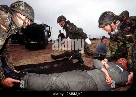 Le personnel médical du Centre de sauvetage de l'Armée de l'Air allemande n° 1, place des civières avec une victime simulée, de l'accident de véhicule simulé en arrière-plan, sur le sol lors d'un exercice de victimes massives à Dona Ana Range, fort Bliss, Texas. Les soldats allemands, démontrent leurs techniques de sauvetage aux États-Unis Le personnel de l'hôpital de soutien au combat de l'armée de 396th personnes d'Orogrand, au Nouveau-Mexique, tout en participant à l'exercice d'opérations aériennes tactiques multinationales, le plus important service conjoint au monde. Objet opération/série: ROVING SANDS '97 base: El Paso État: Texas (TX) pays: États-Unis d'AME Banque D'Images