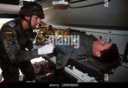 Un technicien médical du centre de sauvetage de l'armée de l'air allemande n° 1 sécurise une victime d'accident simulée et s'étire à l'intérieur d'une ambulance lors d'un exercice de victimes massives à Dona Ana Range, fort Bliss, Texas. Les soldats allemands, démontrent leurs techniques de sauvetage aux États-Unis Le personnel de l'hôpital de soutien au combat de l'armée de 396th personnes d'Orogrande, au Nouveau-Mexique, tout en participant au plus grand exercice d'opérations aériennes tactiques multinationales et de service conjoint au monde. Objet opération/série: ROVING SANDS 97 base: El Paso État: Texas (TX) pays: États-Unis d'Amérique (USA) Banque D'Images