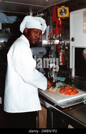 LE caporal ANQUONE Conyer du corps des Marines DES ÉTATS-UNIS tranche et tranche des légumes pour une salade dans le mess du drapeau qui sera servie au commandant de l'unité expéditionnaire maritime de 26th. LE CPL Conyer est déployé avec l’unité expéditionnaire maritime 26th dans le cadre de la Sixième flotte de la Force d’atterrissage à bord de l’USS WASP (LHD 1). Base : USS Wasp (LHD 1) Banque D'Images