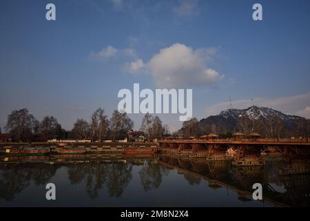 Srinagar, Inde. 14th janvier 2023. Vue sur la rivière Jhelum et la neige couvrait les collines de Zabarwan pendant une journée ensoleillée après une chute de neige fraîche à Srinagar. Le bureau météorologique a prévu un temps sec au Cachemire jusqu'à 14-18 janvier. Crédit : Pacific Press Media production Corp./Alay Live News Banque D'Images