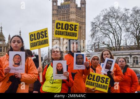 Londres, Royaume-Uni. 14th janvier 2023. Les manifestants tiennent des pancartes et des photos de prisonniers de Guantanamo lors de la manifestation sur la place du Parlement. Des activistes portant des procès-emmêlés de prison orange ont défilé à Westminster en appelant à la fermeture du camp de détention de Guantanamo Bay. 11 janvier a marqué l'anniversaire de 21st depuis l'ouverture de la prison controversée. (Photo de Vuk Valcic/SOPA Images/Sipa USA) crédit: SIPA USA/Alay Live News Banque D'Images