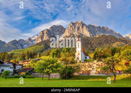 Garmisch Partenkirchen Allemagne, le pic de Zugspitze et la chaîne de montagnes des Alpes avec une petite église dans le village de Grainau Banque D'Images