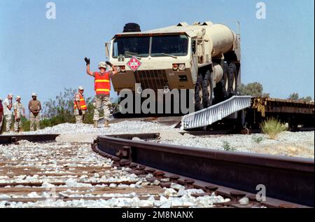 LE SPÉCIALISTE de l'armée Hart de Delta 3/43, 11th Brigade Air Defense Artillery fort Bliss, Texas, guide un camion de carburant tactique à mobilité élargie de M978 en toute sécurité à partir d'un wagon à plateau pendant L'INSTRUCTION sur LES ARMES ET LES TACTIQUES 1-99. Objet opération/série: INSTRUCTION SUR LES ARMES ET LES TACTIQUES 1-99 base: Marine corps Air Station, Yuma État: Arizona (AZ) pays: États-Unis d'Amérique (USA) Banque D'Images