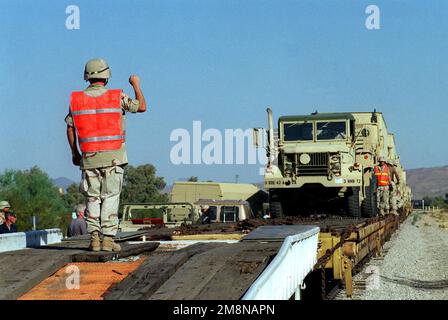 LE SPÉCIALISTE de l'armée Hart de Delta 3/43, 11th Brigade Air Defense Artillery fort Bliss, Texas, guide un camion tactique M939A2 de 5 tonnes en toute sécurité à l'extérieur d'un wagon à plateau pendant L'INSTRUCTION SUR LES ARMES ET LES TACTIQUES 1-99. Objet opération/série: INSTRUCTION SUR LES ARMES ET LES TACTIQUES 1-99 base: Marine corps Air Station, Yuma État: Arizona (AZ) pays: États-Unis d'Amérique (USA) Banque D'Images