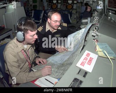 ÉTATS-UNIS Le CAPT Robert D. Jenkins III (à droite), commandant du croiseur à missiles guidé de classe TICONDEROGA, USS PHILIPPINE SEA (CG-58), discute de la position de son navire par rapport à d'autres contacts de surface non identifiés, avec l'officier d'action tactique (TAO) du navire, LE CAPC Pete Winter. LA MER DES PHILIPPINES participe au deuxième jour de l'opération Allied Force de l'OTAN. Cette mission appuie directement l'opération Allied Force de l'OTAN. Objet opération/série: FORCE ALLIÉE pays: Mer Adriatique Banque D'Images