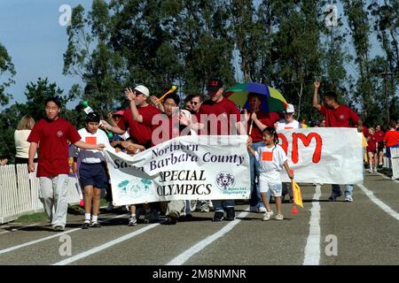 Lors des cérémonies d'ouverture de la base aérienne de Vandenberg en 1999, en Californie, dans le nord des Jeux olympiques spéciaux du comté de Santa Barbara, les concurrents du comté de Santa Clara portent la bannière des Jeux olympiques spéciaux. LES membres DE LA Force aérienne AMÉRICAINE de Vandenberg AFB marchent avec les concurrents. L'événement a eu lieu sur 17 avril 1999. Cette image est vue dans l'édition d'avril 1999 d'AIRMAN Magazine. Base: Vandenberg Air Force base État: Californie (CA) pays: États-Unis d'Amérique (USA) Banque D'Images