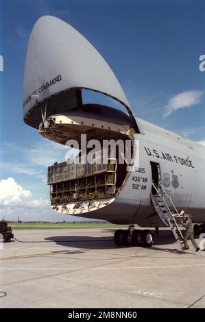 Un C-5B Galaxy de la 436th Airlift Wing, Douvres, Delaware, est assis avec sa visière de nez vers le haut exposant les rampes hydrauliques, qui seront bientôt abaissées, car il est prêt à télécharger quatre camions à combustible pour le 100th Supply Squadron de RAF Mildenhall, au Royaume-Uni. L'appareil s'agenouille sur le train d'atterrissage pour faciliter le déchargement des camions. Les camions-citernes sont nécessaires pour soutenir les opérations accrues de navires-citernes KC-135 à la RAF Mildenhall dans le cadre de L'opération ALLIED FORCE de l'OTAN. L'objectif DE LA FORCE ALLIÉE est de dégrader et de nuire à la structure militaire et de sécurité que le président Milosevic (Pres yougoslaves Banque D'Images