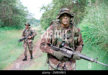 Privé première classe Valdez (avant-terrain) de Echo 2/8, 1st peloton, 1st squid, portant un fusil M16A2 5,56mm, fournit un contact radio pour son équipe lors d'une patrouille dans la jungle. Non identifié Marine en arrière-plan porte également un fusil M16A2 5,56mm. Les Marines de Echo Company, 2nd Bataillon, 8th Marine Regiment font partie des États-Unis Détachement de sécurité Panama, Forces maritimes du Sud. Les Marines assurent la sécurité pendant le passage du canal de Panama et des bases américaines au gouvernement panaméen. Base: Fort Howard pays: Panama (PAN) Banque D'Images