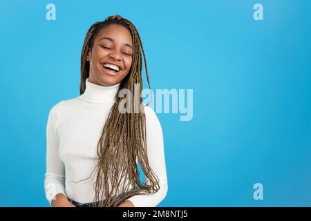 Une femme africaine heureuse avec des tresses qui ferment les yeux Banque D'Images