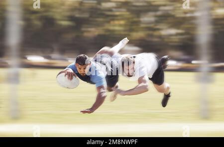 Un joueur de rugby de course mixte qui a fait un essai lors d'un match de rugby à l'extérieur sur un terrain. Athlète hispanique masculin faisant une plongée pour essayer et gagner le jeu pour Banque D'Images