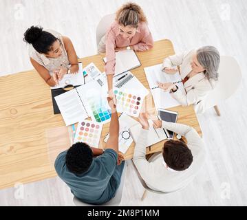 Groupe de cinq hommes d'affaires divers ayant une réunion à une table dans un bureau d'en haut. Des collègues heureux se serrant la main tandis que leurs collègues claque Banque D'Images