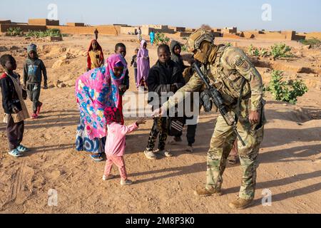 Base aérienne 201, Niger. 6th janvier 2023. ÉTATS-UNIS Airman Lorenzo Bennette, officier supérieur de la Force aérienne, 409th escadron de la sécurité expéditionnaire, membre de la Force de réaction rapide (FQR), remet des bonbons à un enfant local près de l'AB 201, au Niger, en janvier. 6, 2023. QRF se postures à l'intérieur et autour de la base pour pouvoir réagir rapidement aux menaces hostiles en développement sur ou immédiatement autour de la base. Crédit : États-Unis Air Force/ZUMA Press Wire Service/ZUMAPRESS.com/Alamy Live News Banque D'Images