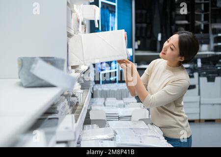 La jeune femme de choisir et d'acheter des articles ménagers Banque D'Images
