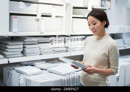 La jeune femme de choisir et d'acheter des articles ménagers Banque D'Images
