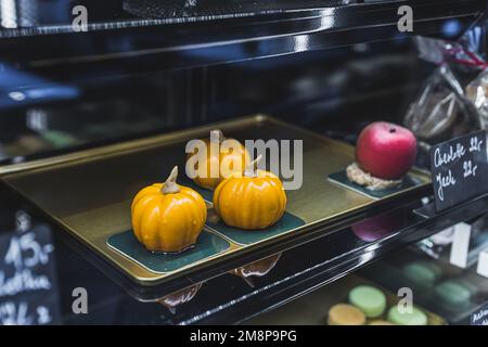 Petits desserts à la mousse en forme de citrouille et de pomme en vente dans la boulangerie du café. Desserts d'automne. Gâteries sucrées. Prise de vue horizontale en intérieur. Photo de haute qualité Banque D'Images