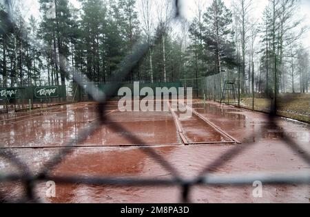 terrain de tennis de sable vu à travers la clôture, terrain rouge, hiver Banque D'Images