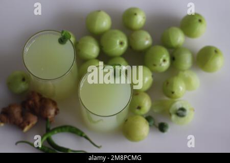 Le jus d'amla ou de groseille indienne est une boisson parfaite du matin avec de multiples avantages pour la santé. Fait avec un peu de gingembre et de piment vert. Prise de vue sur fond blanc Banque D'Images