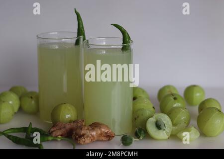 Le jus d'amla ou de groseille indienne est une boisson parfaite du matin avec de multiples avantages pour la santé. Fait avec un peu de gingembre et de piment vert. Prise de vue sur fond blanc Banque D'Images