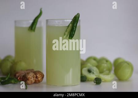 Le jus d'amla ou de groseille indienne est une boisson parfaite du matin avec de multiples avantages pour la santé. Fait avec un peu de gingembre et de piment vert. Prise de vue sur fond blanc Banque D'Images