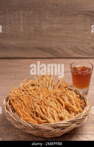 Champignons à aiguille dorés frits avec sauce douce et épicée Banque D'Images