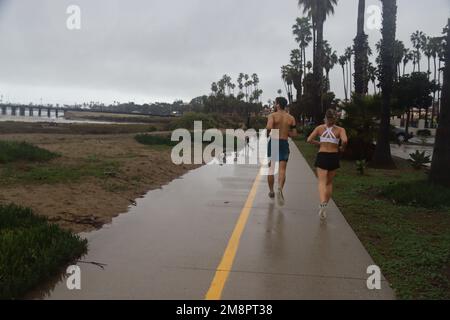 Santa Barbara, Californie, États-Unis 14th janv. 2023. Un homme et une femme font du jogging sous la pluie sur le sentier de vélo le long d'East Beach, Santa Barbara (Credit image: © Amy Katz/ZUMA Press Wire) USAGE ÉDITORIAL SEULEMENT! Non destiné À un usage commercial ! Crédit : ZUMA Press, Inc./Alay Live News Banque D'Images