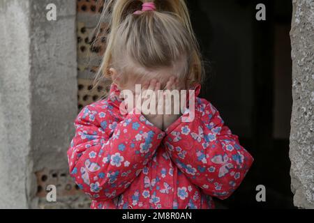 Portrait d'une petite fille triste dans un bâtiment en ruines. Réfugiés, crise de guerre, catastrophe humanitaire concept. Banque D'Images