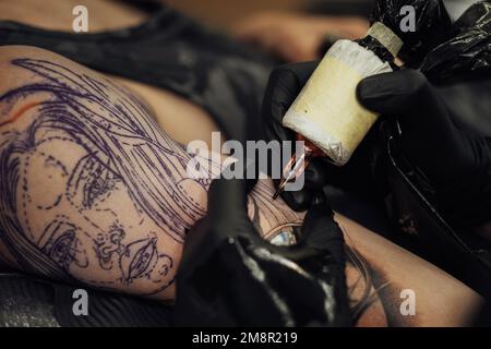 Gros plan du processus de création d'art de tatouage, l'artiste s'inspire de la peau du client Banque D'Images