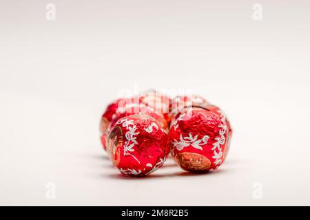 gros plan de plusieurs bonbons de noël en forme de boule de chocolat enveloppés de papier d'aluminium rouge Banque D'Images