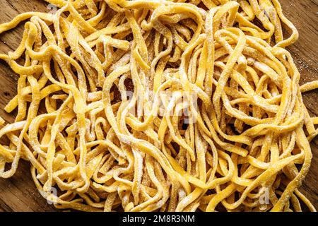 Pâtes faites maison. Pâtes italiennes fraîches et crues sur une table de cuisine en bois. Photo de haute qualité Banque D'Images