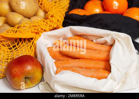 Fruits et légumes frais de la ferme. Sacs à provisions réutilisables. Sac en tissu, sac en filet, sac à ficelle. Rempli de légumes et de fruits. oranges. Carotte close-u Banque D'Images