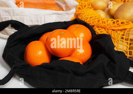 Fruits et légumes frais de la ferme. Sacs à provisions réutilisables. Sac en tissu, sac en filet, sac à ficelle. Rempli de légumes et de fruits. oranges. Gros plan. Banque D'Images