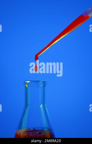 Une goutte de sang. Pipette. Sur fond bleu. Flacon médical avec liquide rouge. Flacon de sang. Liquide rouge qui s'égoutte. Une goutte de rouge. Tests, sang grou Banque D'Images