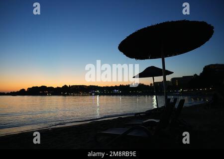 Plage sur la mer Méditerranée dans la Reviera turque. Côte au coucher du soleil avec parasols près d'Alanya en Turquie. Banque D'Images