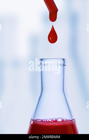 Une goutte de sang. Pipette. Flacon médical avec liquide rouge. Flacon de sang. Liquide rouge qui s'égoutte. Une goutte de rouge. Tests, groupe sanguin. Banque D'Images