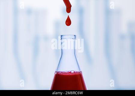 Une goutte de sang. Pipette. Flacon médical avec liquide rouge. Flacon de sang. Liquide rouge qui s'égoutte. Une goutte de rouge. Tests, groupe sanguin. Banque D'Images