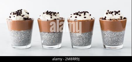 Une rangée de mousses au chocolat chia pudding parfaits garni de boules de chocolat. Banque D'Images