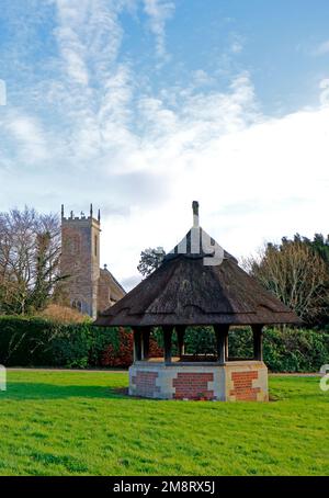 Une vue sur la maison de pompe à puits de chaume sur le pittoresque village vert dans les Norfolk Broads à Woodbastwick, Norfolk, Angleterre, Royaume-Uni. Banque D'Images