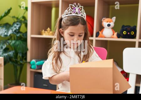 Adorable fille blonde étudiante portant le papier de coupe de la couronne de princesse à la maternelle Banque D'Images