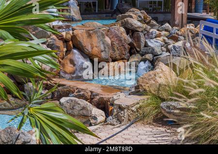 Vue rapprochée de l'intérieur de la fontaine avec étang artificiel parmi les pierres sur le territoire de l'hôtel. Aruba. Banque D'Images