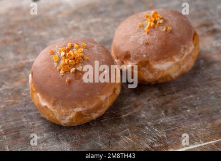 Gros jeudi. Photos de beignets avec garniture de cerise et glaçage. Beignets disposés sur un fond rustique. Banque D'Images