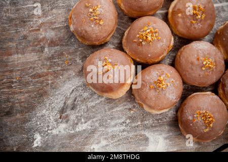 Gros jeudi. Photos de beignets avec garniture de cerise et glaçage. Beignets disposés sur un fond rustique. Banque D'Images