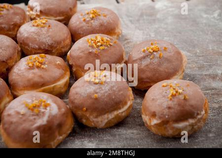 Gros jeudi. Photos de beignets avec garniture de cerise et glaçage. Beignets disposés sur un fond rustique. Banque D'Images