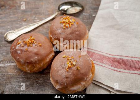 Gros jeudi. Photos de beignets avec garniture de cerise et glaçage. Beignets disposés sur un fond rustique. Banque D'Images